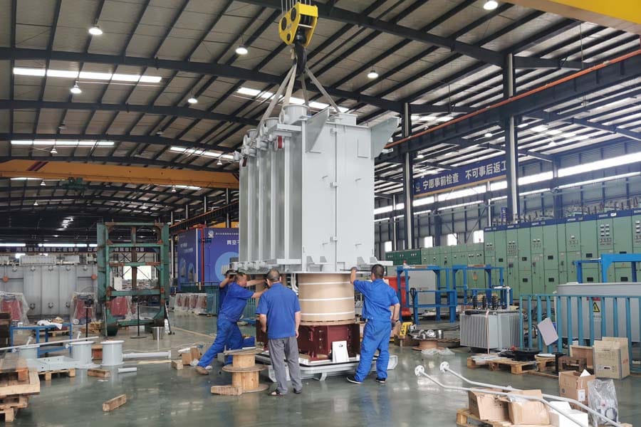 16000kVA oil-immersed transformer tank lowering onto active part — crane assembly operation Zhongxin General factory