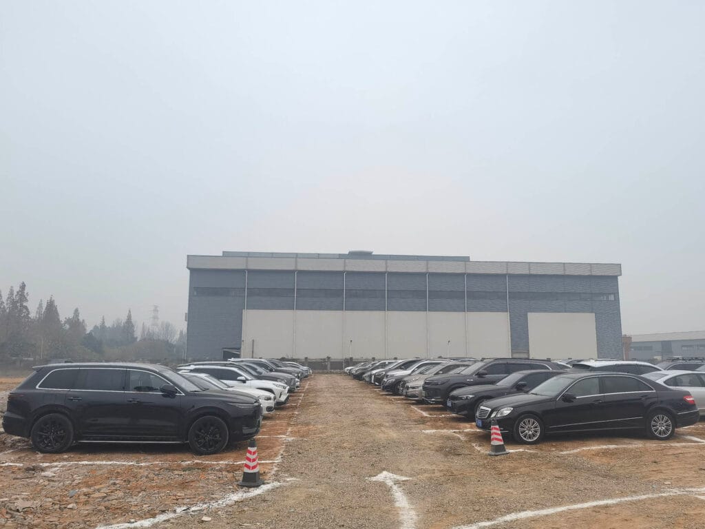 Temporary parking lot completely full at Boruian ceremony with over 100 vehicles by 9:42 AM