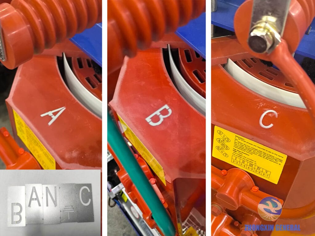 Close-up photo showing custom-applied Phase“A”, “B”, “C”, and ground symbol markings on a transformer’s epoxy resin surface, created using laser-cut stencils and high-temperature paint.