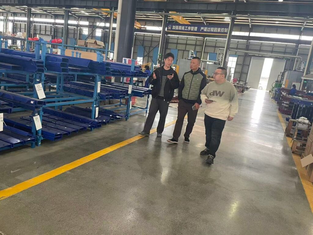Chengdu Construction Engineering Group delegation touring Zhongxin General power distribution equipment manufacturing workshop and discussing technical details with the production team