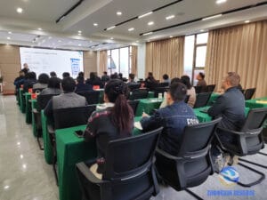 Wide view of the Zhongxin General training conference room with approximately 30 staff attending a session on KYN61-40.5 armoured withdrawable AC metal-enclosed switchgear, with technical specifications projected on the large screen.