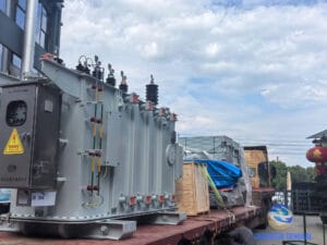 16,000 kVA 35kV OLTC transformer loaded on heavy transport truck — view from workshop toward factory gate, Zhongxin General April 2026