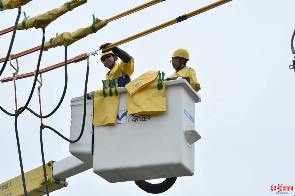 Insulated bucket truck operator making live high-voltage connection at overhead distribution line — mobile substation bypass, Shuangliu Chengdu 2023