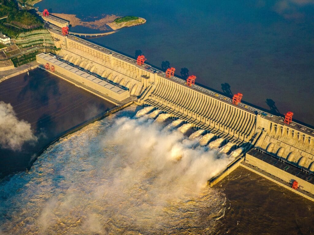 Aerial photograph of Three Gorges Dam with spillway gates open and water discharging at full flow
