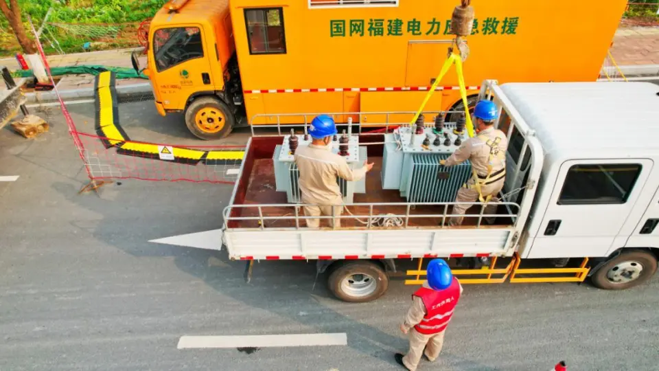 Crane lifting new oil-immersed distribution transformer from transport flatbed — live replacement operation, Yongding District Fujian 2024