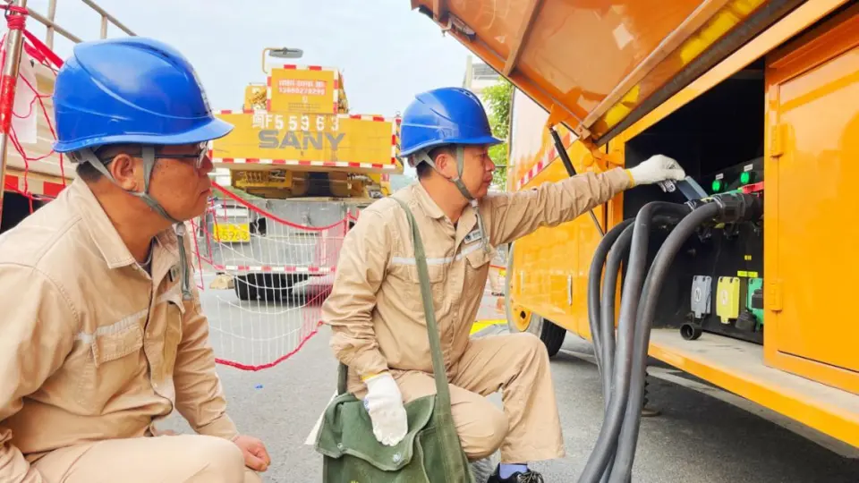 Crew member inspecting cable connection interfaces on mobile box-type substation vehicle — Yongding District Fujian live replacement 2024