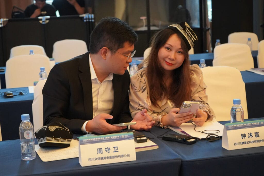 Kevin Z, Director of International Trade at Sichuan Zhongxin General Electric Energy Co., Ltd., networking with Chengdu Commercial Association member enterprise representatives during the break at the Jizzakh investment promotion event, May 22, 2026