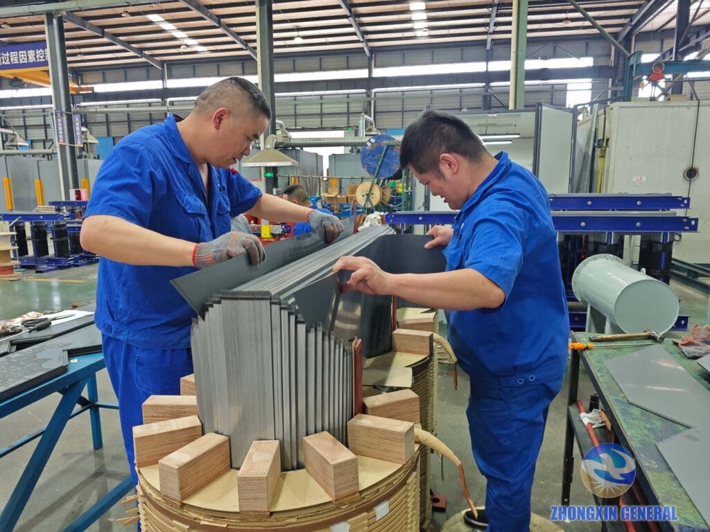 Two technicians building the top core yoke of a 5000 kVA oil-immersed transformer — Zhongxin General