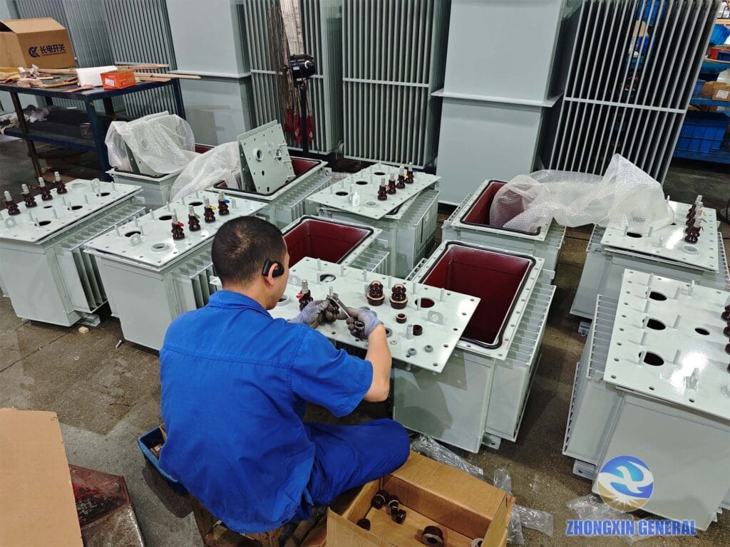 Outer tank shell being installed on 50 kVA oil-immersed transformer active part — Zhongxin General factory