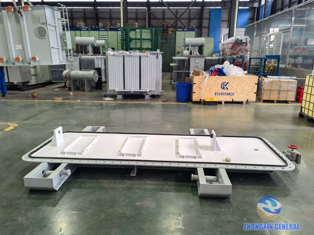 Oil conservator top cover component of 16000 kVA transformer laid on factory floor before installation — Zhongxin General