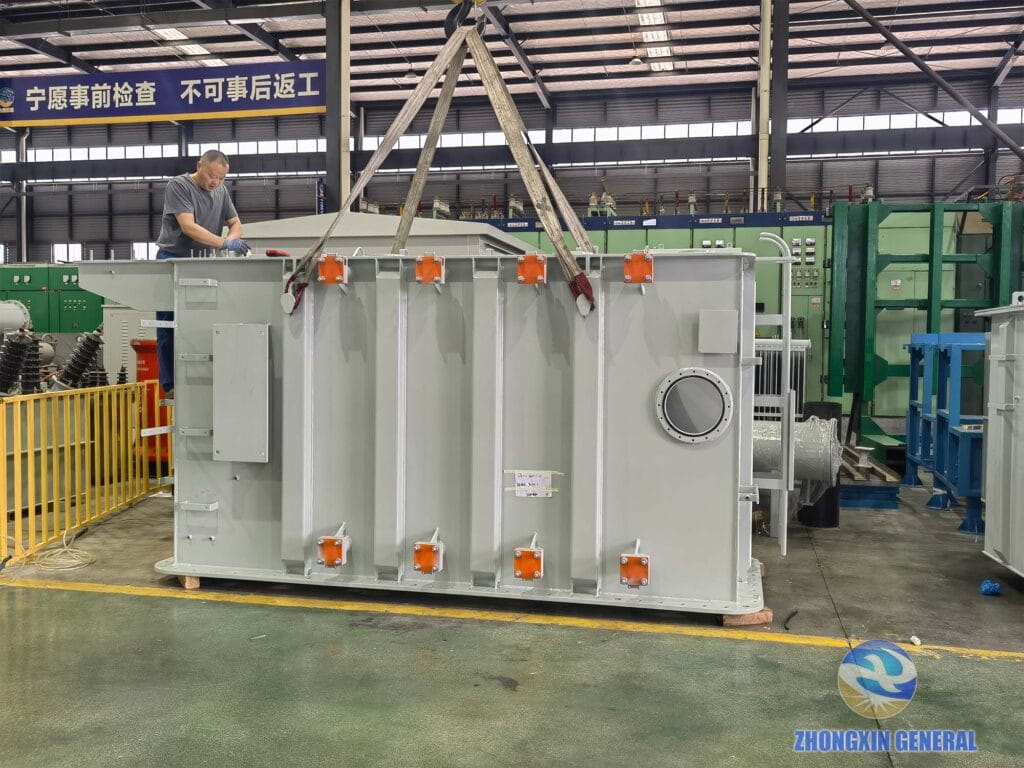 16000 kVA oil-immersed transformer tank being crane-lifted with technician inspecting from top — Zhongxin General