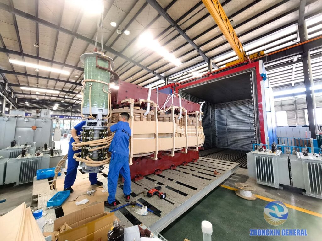 Two technicians loading the 63000kVA transformer active part into vacuum drying equipment — Zhongxin General factory