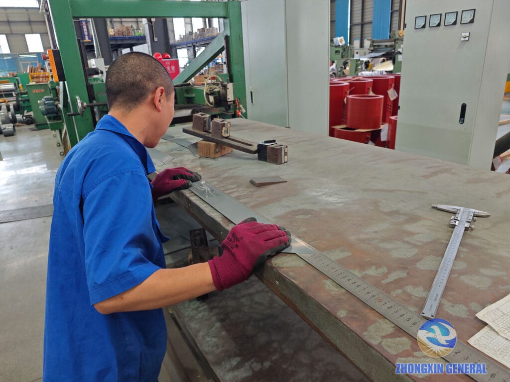Technician measuring cut silicon steel lamination length with calipers