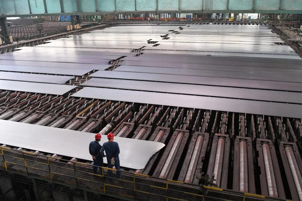 Technician inspecting silicon steel sheet on the roller conveyor at Hunan Valin Lianyuan Steel