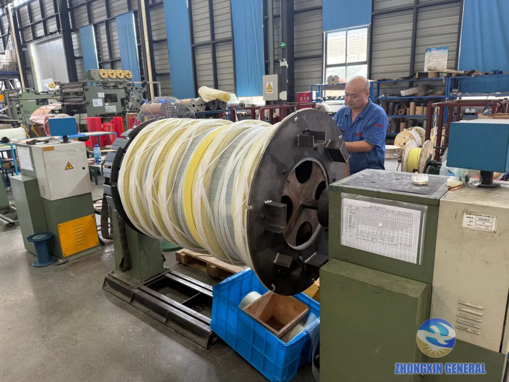 Worker winding a high-voltage coil at Zhongxin General Electric factory