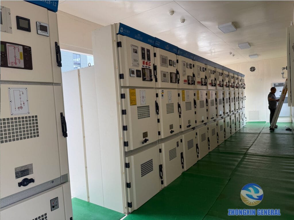 Switchgear panels arranged in sequence inside the prefabricated cabin with a technician inspecting electrical connections