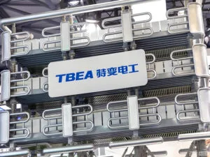 TBEA high-voltage power transformer on display at an industry exhibition, showcasing the company's flagship power transmission equipment with its signature silver cooling radiators and precision-engineered metal piping