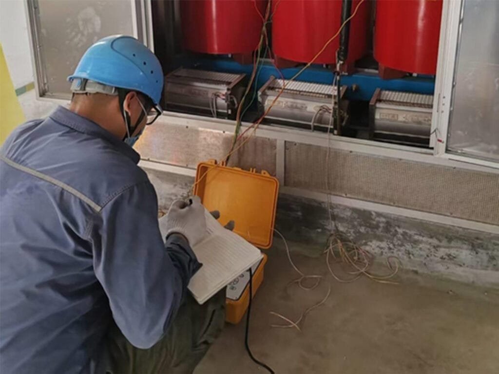 Technician records dry type transformer inspection data on site maintenance log