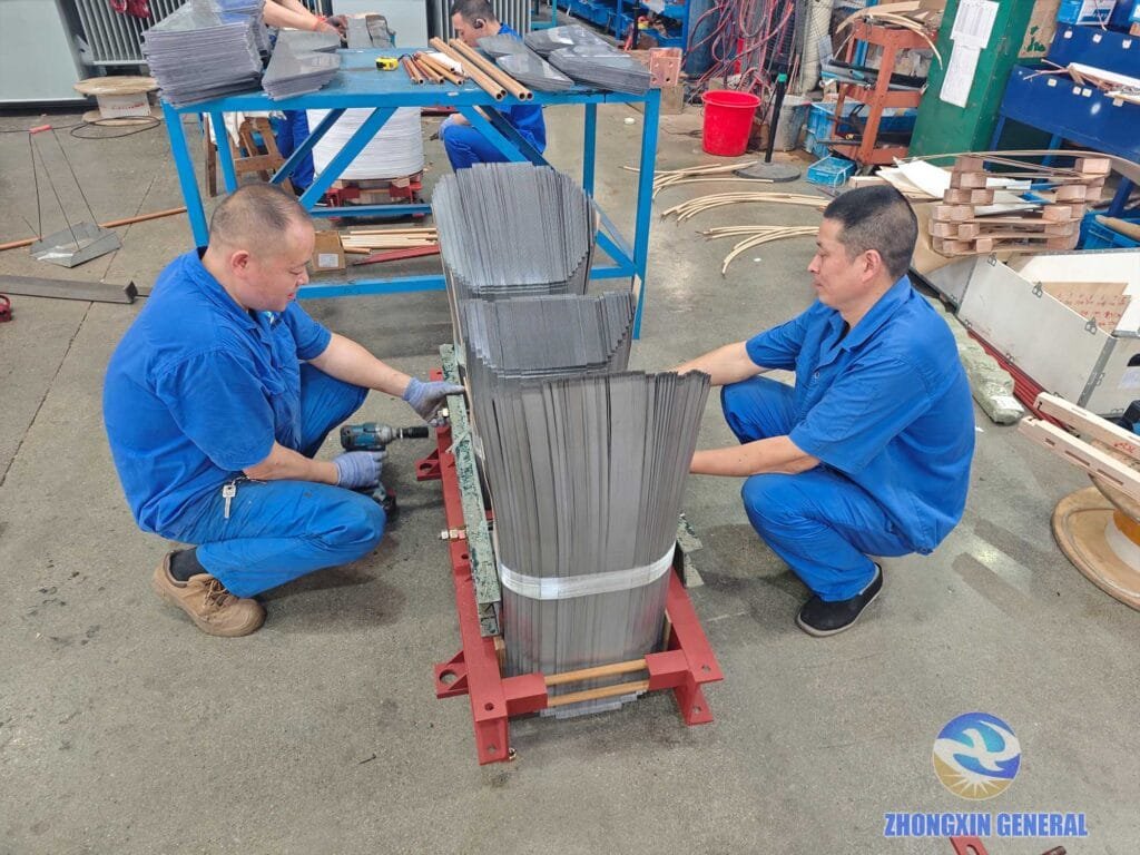 Two workers removing upper core frame for winding installation