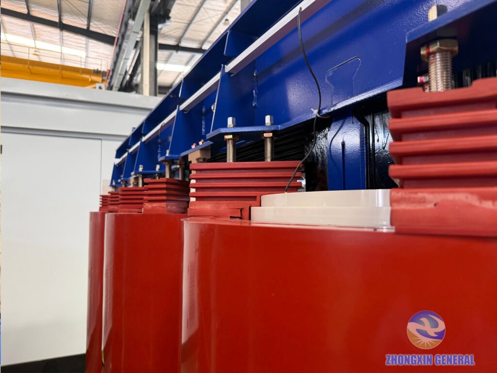 close-up of dry-type transformer top clamp assembly with blue paint galvanized studs red insulators and black varnished core