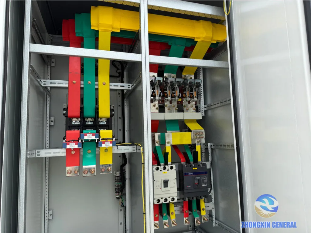 Low-voltage switchgear compartment inside prefabricated substation with color-coded copper busbars and circuit breakers