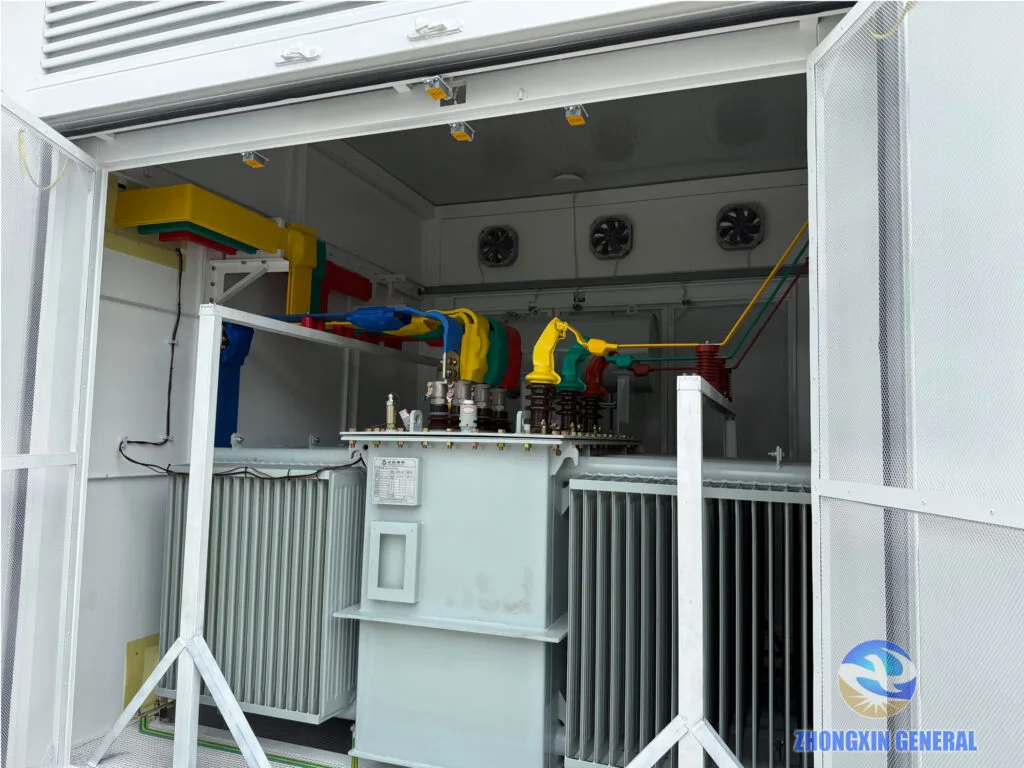 Oil-immersed transformer installed inside prefabricated cabin substation with cooling fans and busbar connections