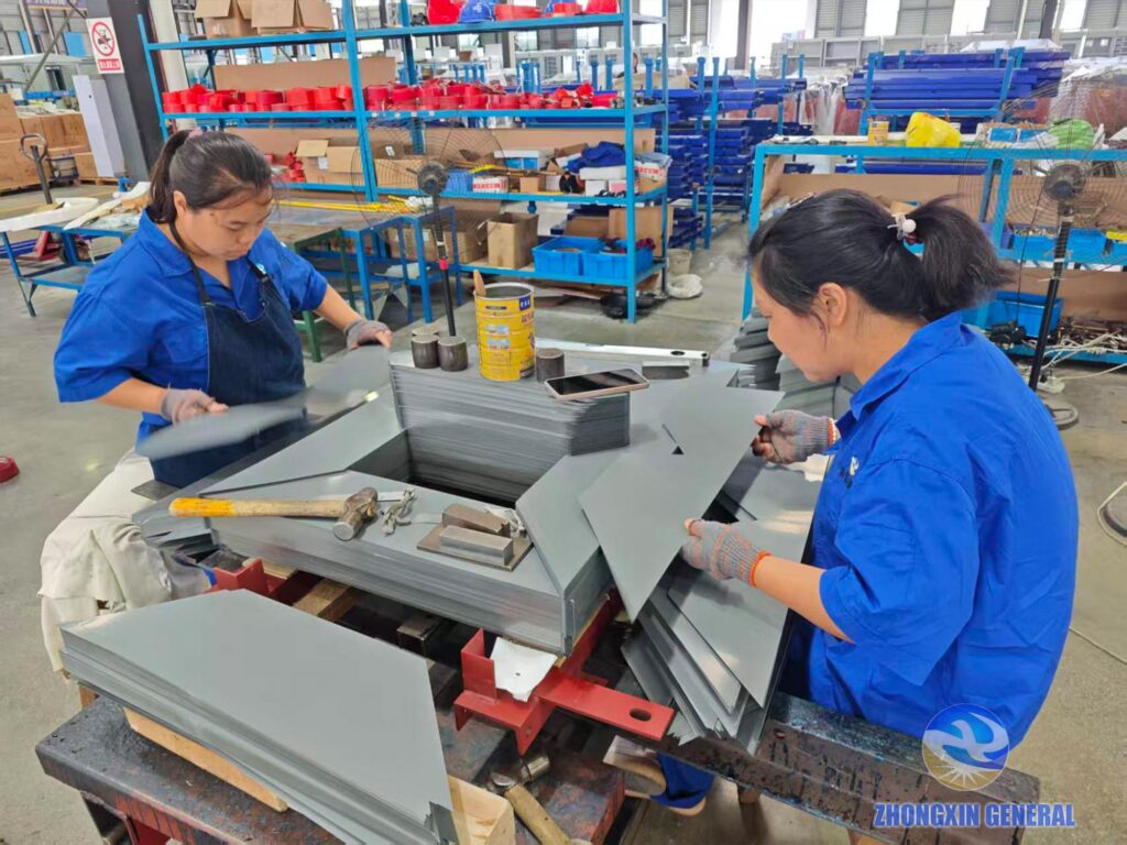 Two factory workers building silicon‑steel core for 630 kVA oil‑immersed distribution transformer