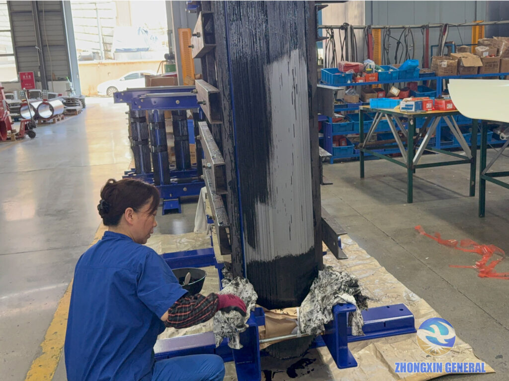 Worker applying insulation coating to a 5250 kVA dry-type transformer core in the final assembly stage